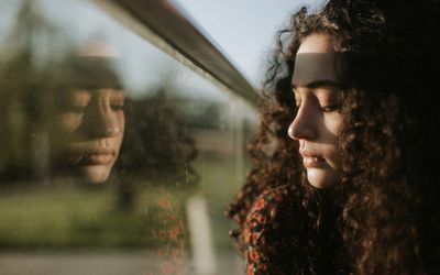 年轻女子透过窗户看的特写镜头