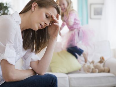 Stressed woman with daughter jumping behind her