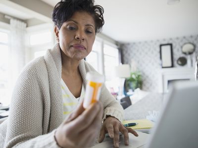 读在膝上型计算机的妇女处方瓶标签