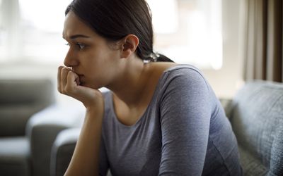 生气妇女坐沙发单独在家