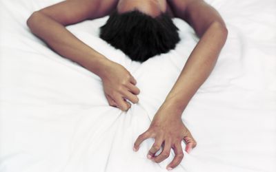 woman grabbing sheets during sex