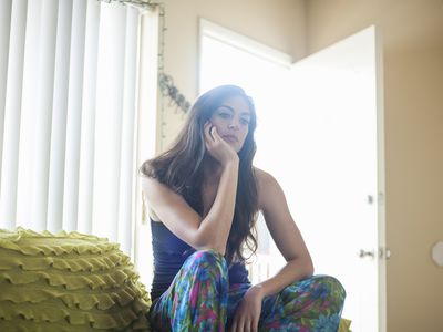 哀伤的妇女坐沙发的胳膊