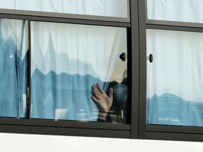 Person looking out window during quarantine