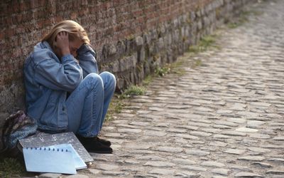 陷入困境的少女坐在墙上。