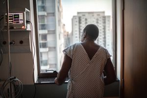 Senior patient looking through window at hospital