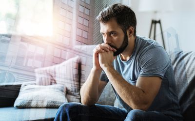 想一想。坐在空的房间里的体贴的严肃的用胡子的人握手在嘴和认为。“class=