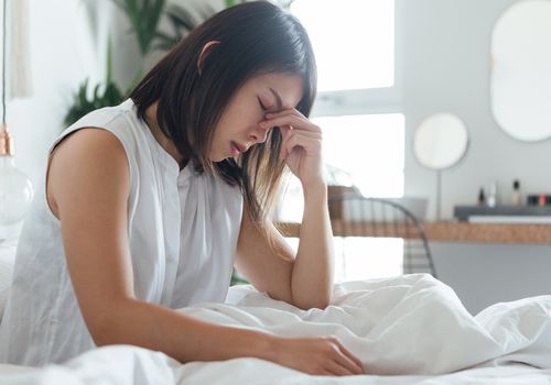 woman in bed with a headache