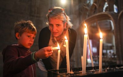 母亲和太阳在教堂里点蜡烛