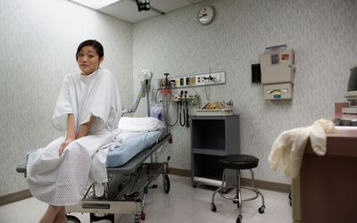 低角度的一个年轻的亚洲女人坐在一个检查表。