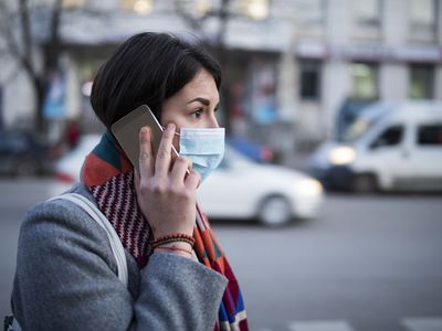Young Woman With Face Mask Talking On The Phone