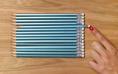 一名妇女把铅笔和其他铅笔推成一条直线