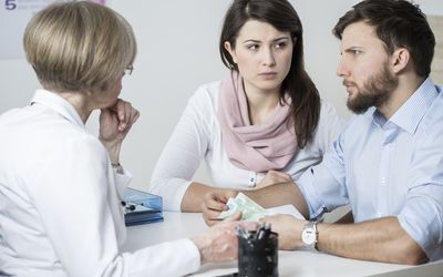 模型姿势作为担心的夫妇与医生咨询