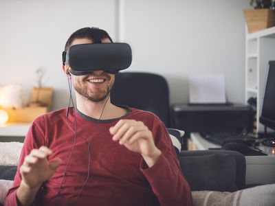 Man using virtual reality headset, sitting on couch