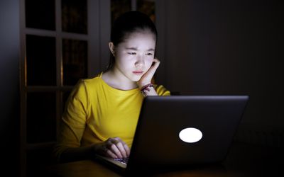 看计算机屏幕的妇女在晚上