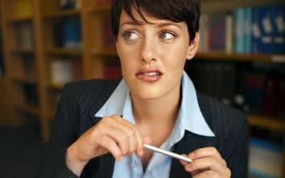 关闭坐在书桌的女实业家正面图焦急地完成一项能力测试