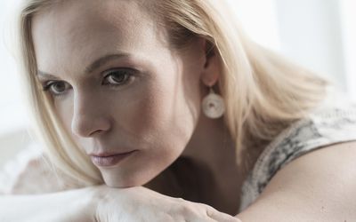 沉思的成年女子躺在床上