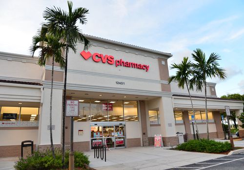 米色CVS商店的入口坐落在两排棕榈树之间。