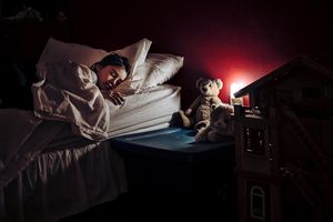 睡在床上的女孩只有夜晚的灯光。