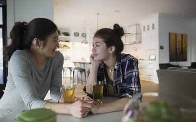 握手饮用的茶的母亲和女儿