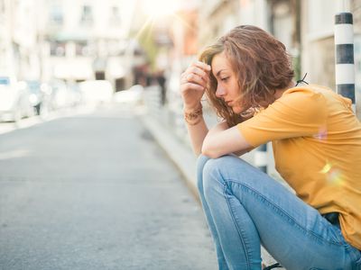 坐在路边的年轻女子看起来很紧张