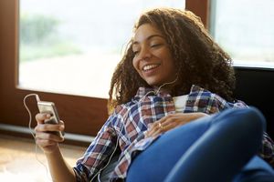 女子使用MP3播放器在家里。