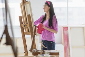 一个十几岁的女孩在画室画画。