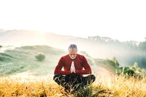 一位年长的老人在雾蒙蒙的早晨在大自然中冥想。副本的空间。