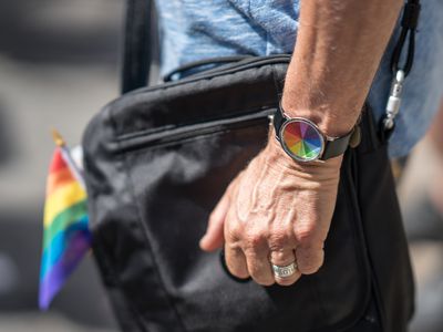 婚戒的人与彩虹手表和旗子