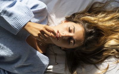 美丽的年轻女子闭着眼睛躺在床上的肖像