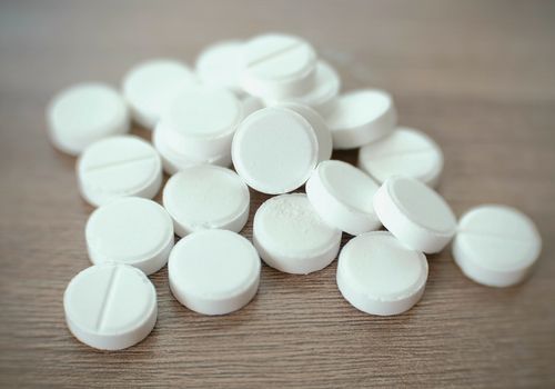 一堆圆的白色药片在桌上
