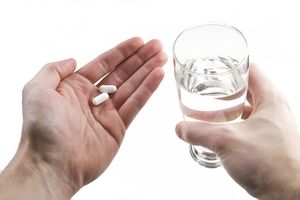 手里拿着药片的人