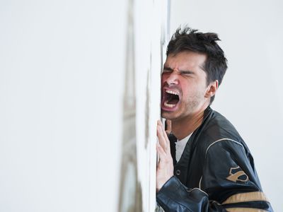 沮丧的中年男子对着墙尖叫