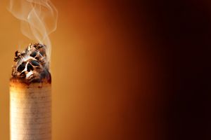 烟头燃烧的特写镜头，灰烬中有头骨