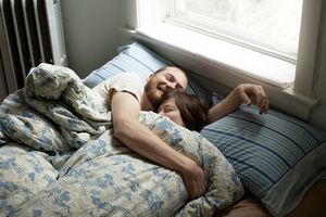 happy couple cuddling in bed