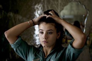 年轻女子做她的头发“class=