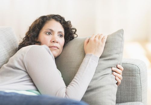 worried woman on sofa