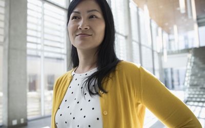 唱片小点礼服和黄色羊毛衫的纵向确信的亚洲女实业家看