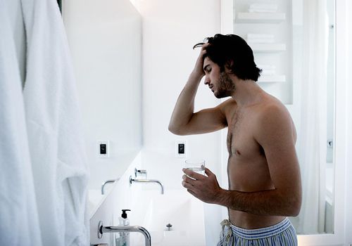 Man rubbing head in bathroom