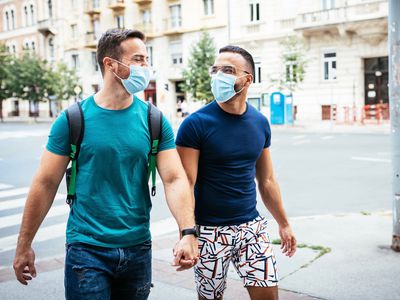 two gay men walking with masks on