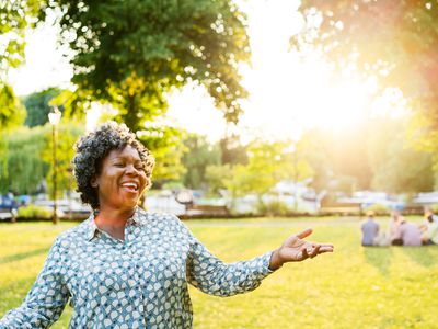 微笑在阳光下的愉快的妇女