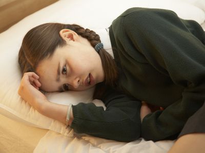 一个小女孩蜷缩在床上