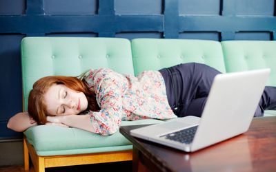 Woman asleep on sofa with laptop