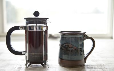 咖啡柱塞和杯子在桌上