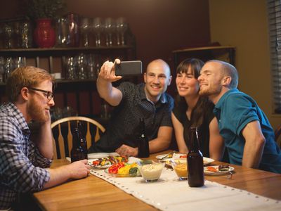 一个年轻人悲伤地坐着，他的朋友在拍照