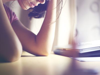 紧张的女人肘放在桌上的笔记本电脑前