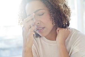 接触她的面孔的中期妇女。