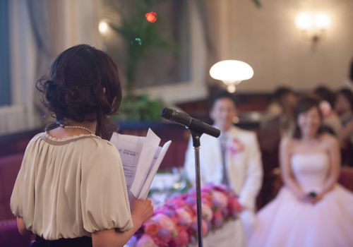 在一场婚礼上，一位女士站在麦克风前发表演讲