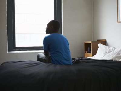 lonely man sitting on the bed