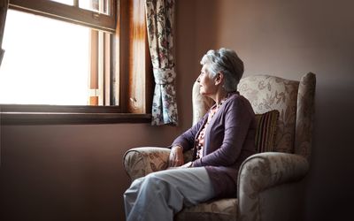 单独坐一名资深妇女的一名资深妇女在她的客厅