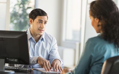 美国、新泽西、泽西城，求职面试时，一对男女坐在办公桌旁交谈